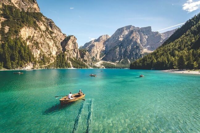 A stock image of a people boating on a mountain lake.